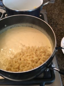 macaroni and chhese adding pasta